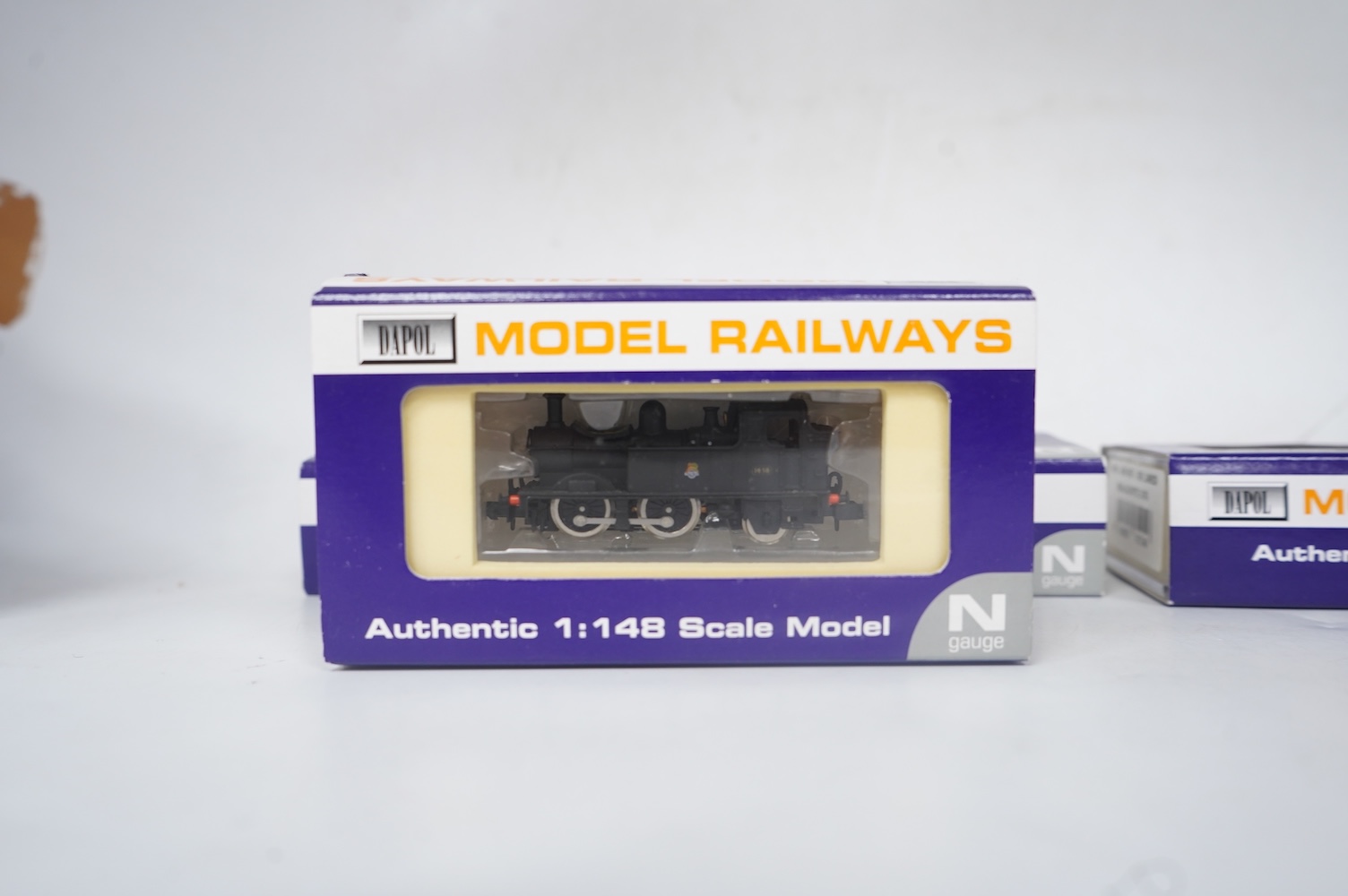 Four boxed Dapol N gauge railway locomotives; two BR Class Q1, both 33040 (ND-076B), one in associated box, a BR Class 14xx, 1458 (ND002) and an SR Class M7, 676 (ND-046). Condition - good.